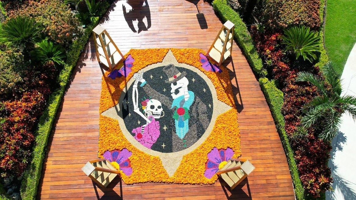 A wood deck with a colorful sawdust tapestry for Day of the Dead